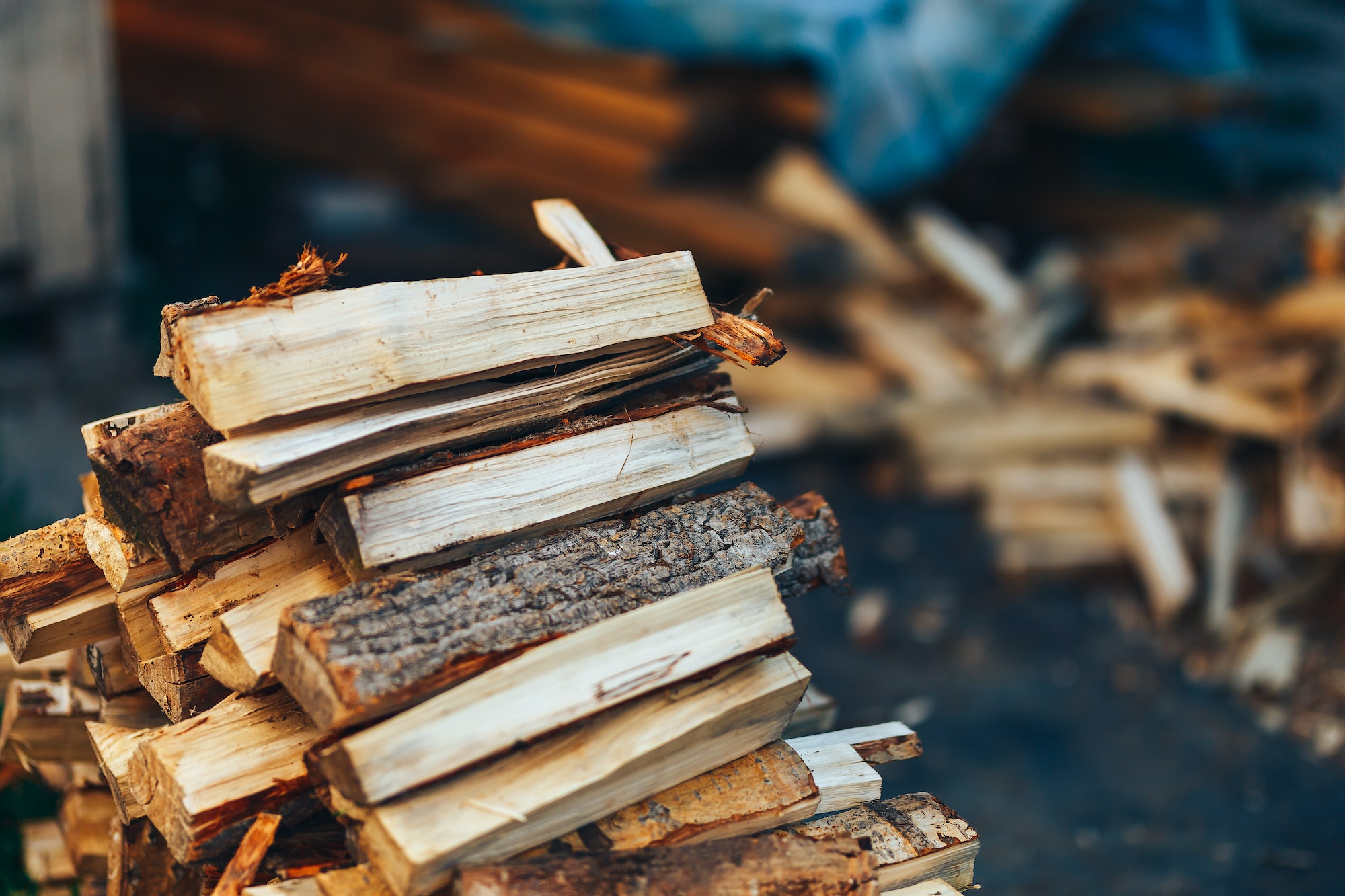 A pile of stacked firewood, prepared for heating the house. Gathering fire wood for winter or